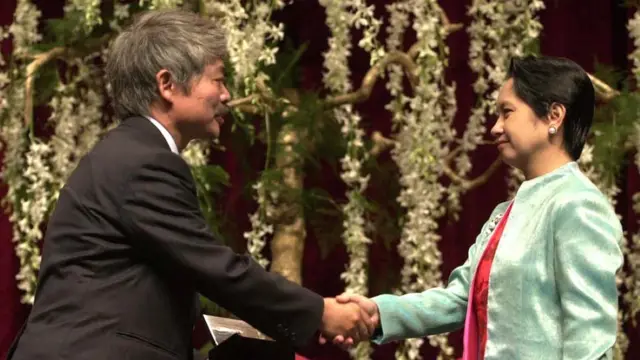 Then-Philippine president Gloria Arroyo (R) congratulating Tetsu Nakamura (L),