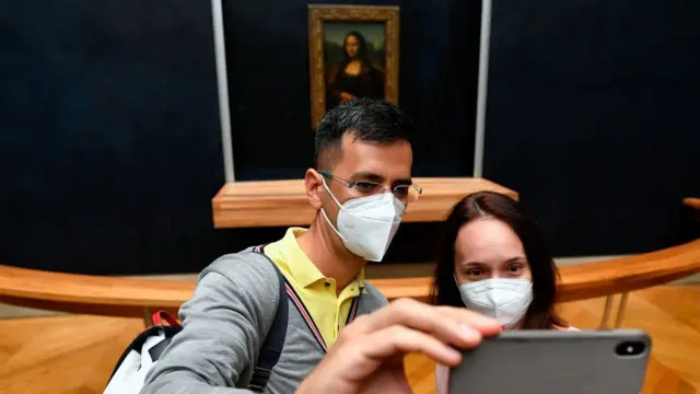 Pessoas tirando selfiesacar bonus galera betfrente à a Mona Lisa no Museu do Louvre