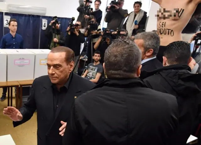 Berlusconi'yi oy verdiği sırada bir FEMEN aktivisti protesto etti. Aktivistin göğsünde "Berlusconi süren doldu" yazıyor.