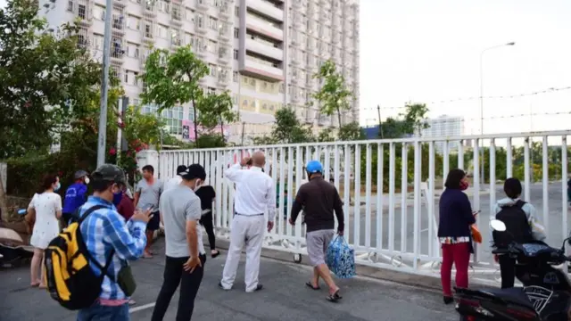 Nhiều người lo lắng đứng ngoài cổng khu cách ly để tiếp tế cho người nhà bên trong