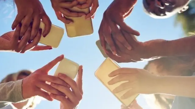 પાંચ લોકો હાથમાં મોબાઈલ લઈને લોકો ઊભા છે