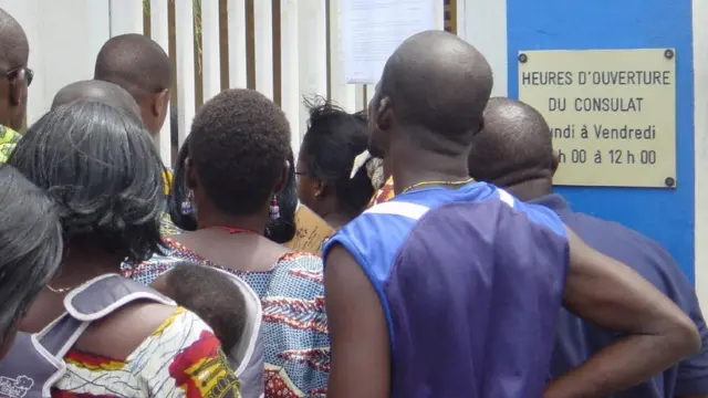 Un groupe de togolais devant la porte d'entrée du consulat d'Allemagne à Lomé.