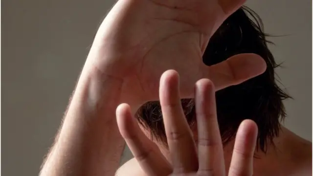 Hombre con las manos delante de la cara.