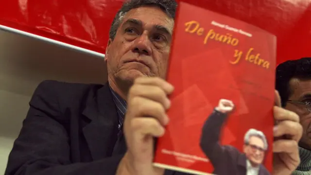 Alfredo Crespo con un libro de Abimael Guzmán