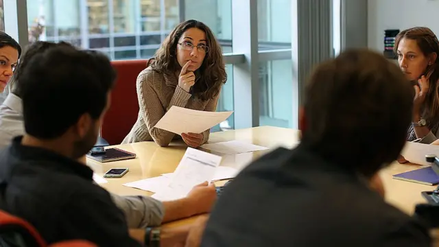 Le Dr Pardis Sabeti assise à une table avec des collègues
