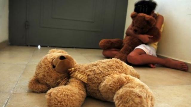 Foto ilustrativa sobre abuso infantil - criança abraça urso de pelúcia