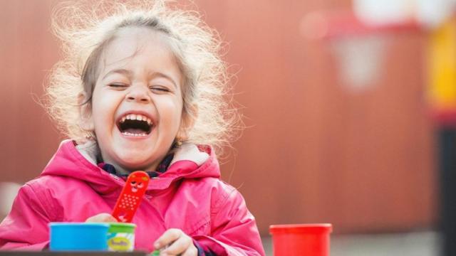 Una niña riéndose a mandíbula batiente