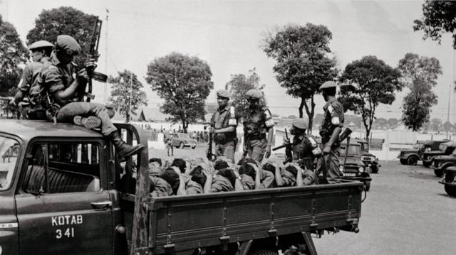 Para prajurit bersenjata mengangkut para terduga anggota Pemuda Rakyat, pada 10 Oktober 1965, dua hari sebelum diumumkannya penangkapan Letkol Untung.