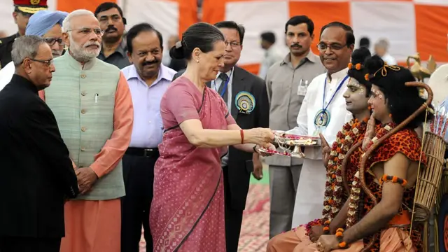 આ વર્ષ 2014ની તસવીર છે, જેમાં કૉંગ્રેસનાં નેતા સોનિયા ગાંધી રામ અને લક્ષ્મણ બનેલા યુવકોની આરતી ઉતારી રહ્યાં છે, અને તેમની પાછળ વડા પ્રધાન નરેન્દ્ર મોદી અને પૂર્વ રાષ્ટ્રપતિ પ્રણવ મુખરજી ઊભા છે.
