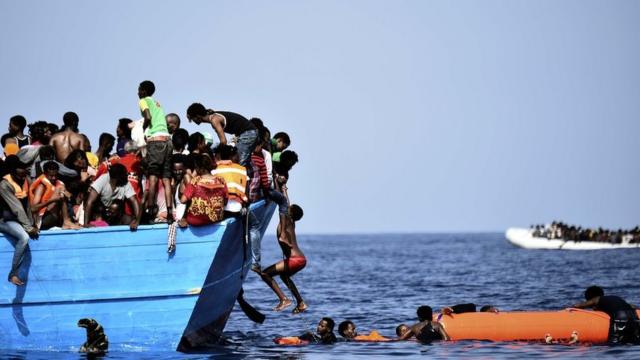Imigrantes dentro de barco de madeira