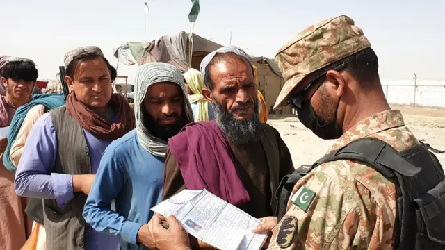 Un soldado pakistaní revisa los documentos de un migrante afgano