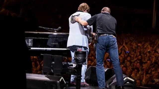 Elton John as dem dey escort am comot stage