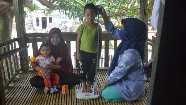 Kader Posyandu mendatangi rumah warga untuk melakukan pengukuran tinggi badan dan penimbangan berat badan kepada dua balita yang bersaudara kandung penderita stunting di Desa Bentang, Kecamatan Galesong Selatan, Kabupaten Takalar, Sulawesi Selatan, Jumat (19/2/2021).