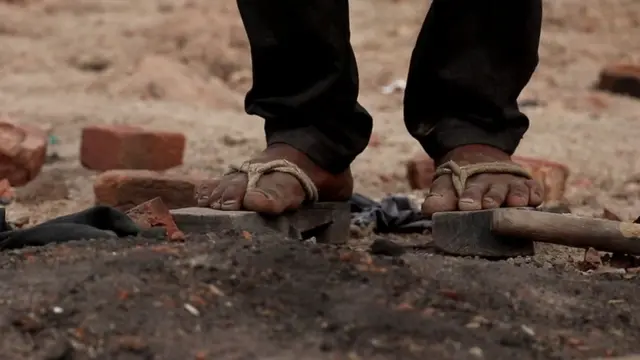 મજૂરો લાકડાના ચંપલ પહેરીને કામ કરે છે
