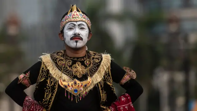 A performer poses in an alley