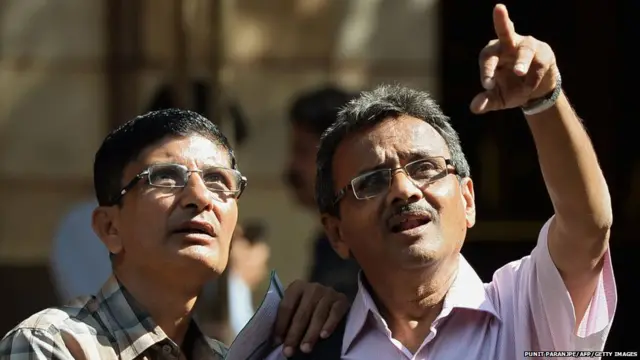 : Indian onlookers watch share prices on a screen on the facade of the Bombay Stock Exchange (BSE) during intraday trade in Mumbai on February 9, 2018.