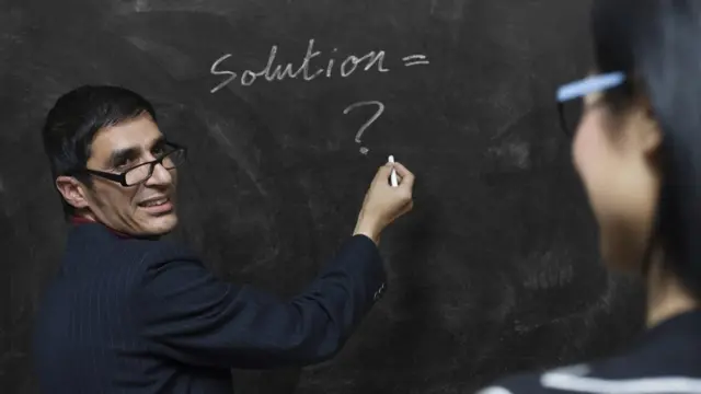 బ్లాక్‌బోర్డు మీద రాస్తున్న ఓ టీచర్