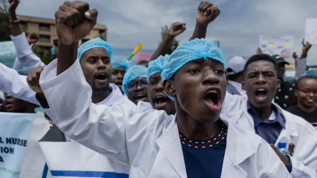 Des médecins kenyans protestent devant le siège du ministère de la santé avec des pancartes pour réclamer de meilleurs salaires et conditions de travail dans la capitale, Nairobi, le 9 avril 2024.