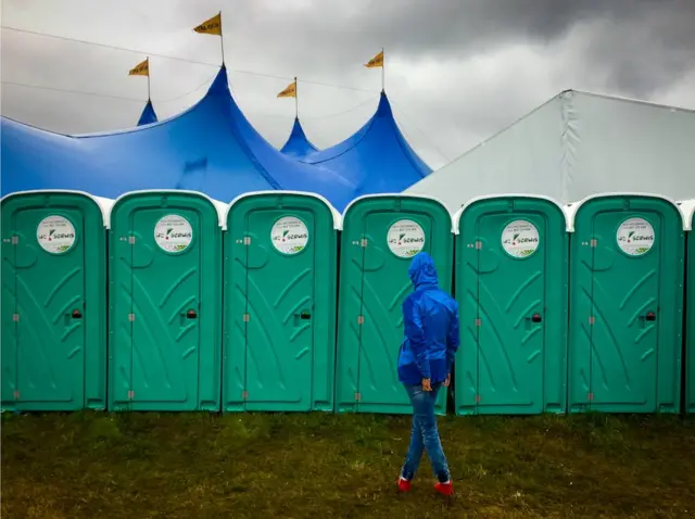 Una mujer en la fila para los baños públicos.