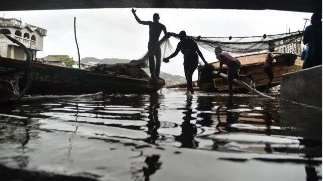 В четвертом по величине городе Гаити Кап-Аитьен рыбаки спасают свои снасти перед приближающимся ураганом