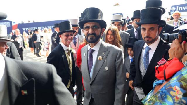 O xeique Mohammed bin Rashid al Maktoum (ao centro, de cartola e óculos) em uma corrida de cavalo na Inglaterra