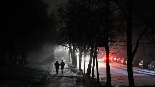 Dos personas caminan por una calle de Kyiv durante un apagón