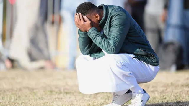 شاب يضع يديه على جبهته متأثرا بالمشهد الجنائزي لضحايا الهجوم الإرهابي على مسجدين في نيوزيلندا