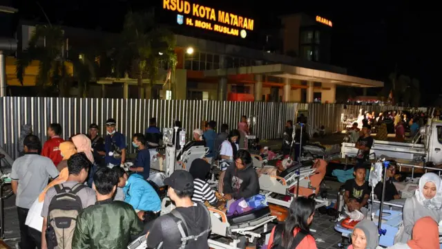Patients are evacuated outside to the Mataram City hospital parking lot after a strong earthquake in Mataram, Lombok island