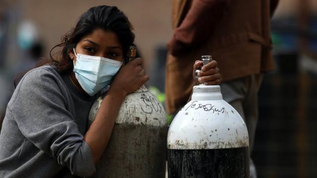 A woman holds on to the oxygen cylinders in Kathmandu, Nepal, 9 May 2021
