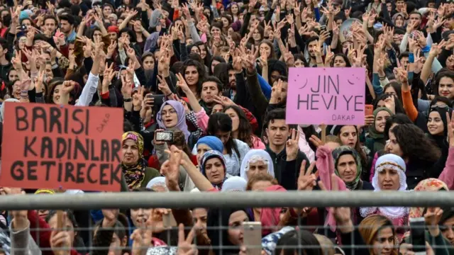 People chant slogans as they hold placards that read, ' Women will bring Peace' during a demonstration to mark International Women's Day in Diyarbakir, southwestern Turkey, on March 8, 2018. / AFP PHOTO / ILYAS AKENGIN (P