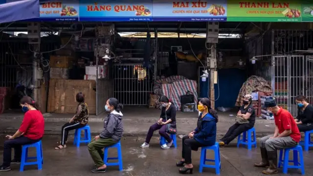 ভিয়েতনামে কোভিড-নাইনটিনের টেস্ট করাতে আসা মানুষ দূরত্ব বজায় রেখে অপেক্ষা করছে