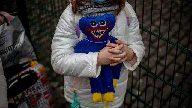 Niña aferrrada a un muñeco