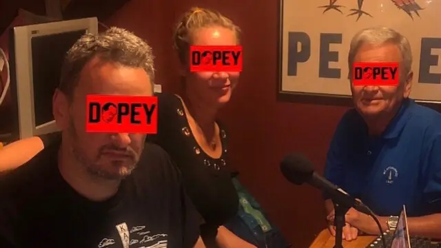 Dave, Linda e Alan sentados na mesa da cozinha, diante do microfone, gravando episódio recente do podcast Dopey