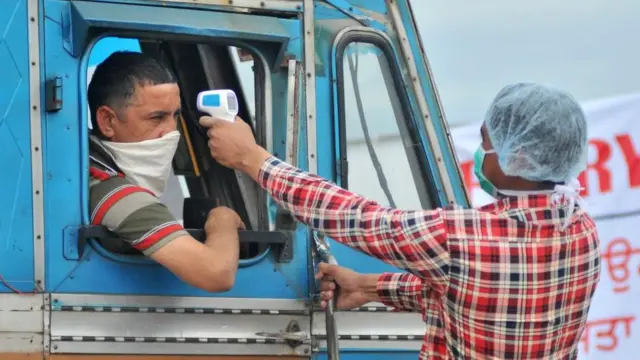 તાપમાન માપનાર આરોગ્ય કર્મચારીની તસવીર