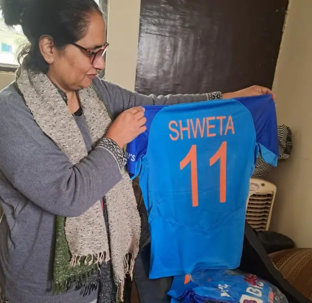 श्वेता की जर्सी दिखाती हुईं उनकी माँ