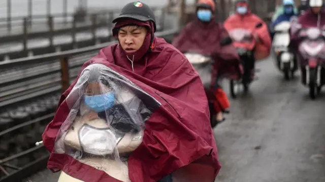 رجل يستقل دراجة بخارية ويخبئ طفلا أمامه