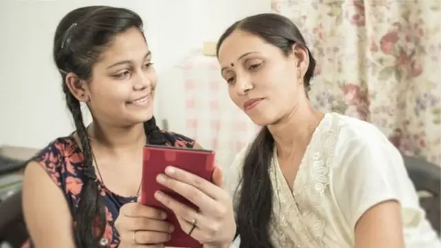செல்போனை பார்க்கும், தாயும் மகளும்