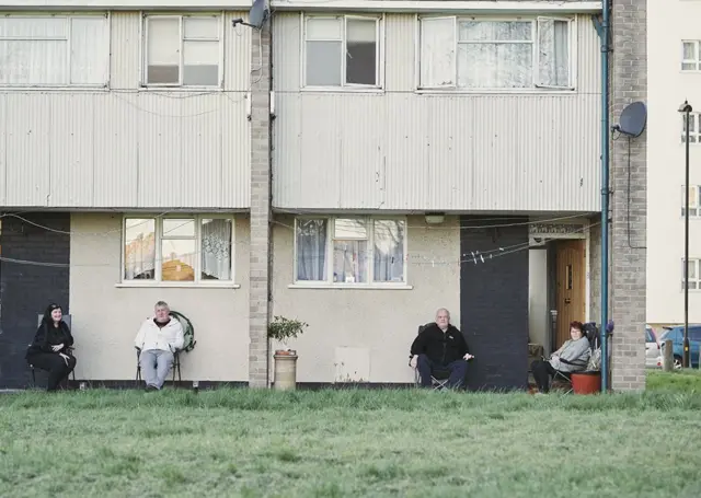 People sitting outside their homes