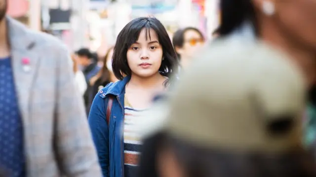 Mulher japonesa caminhando entre a multidão