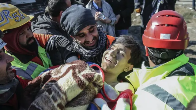 A boy smiles as he is rescued