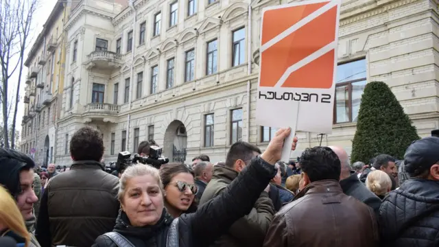 Женщина держит плакат