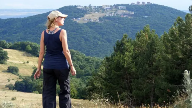 ผู้หญิงยืนหันหลัง ข้างหน้าเป็นภูเขา