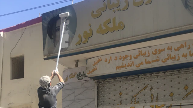 رجل يزي رسماً للدعاية لصالون تجميل