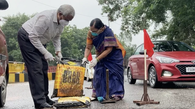 భార్యతో కలిసి రోడ్డు బాగు చేస్తున్న గంగాధర తిలక్