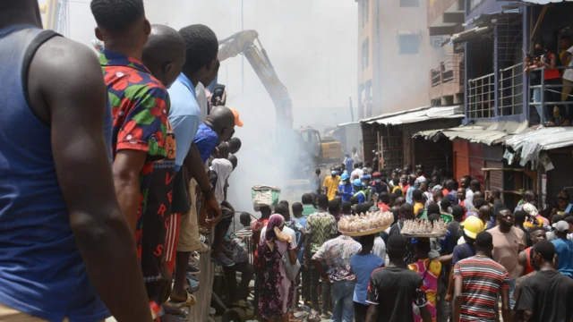 People looking at the scene of a fire in Apongbon market under Eko Bridge in Lagos, Nigeria - Wednesday 23 March 2022
