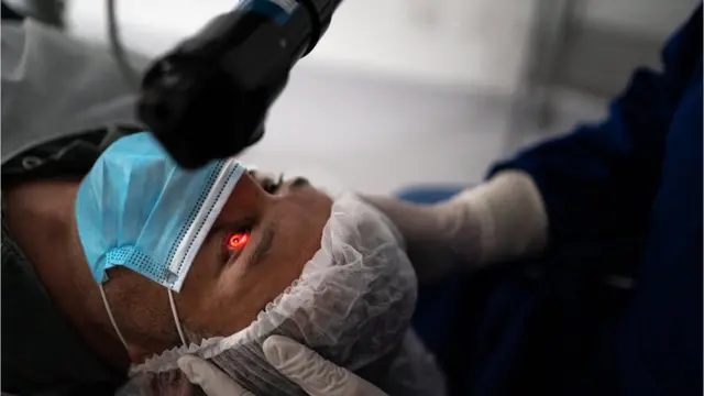 Homem deitado passando por exame de vista