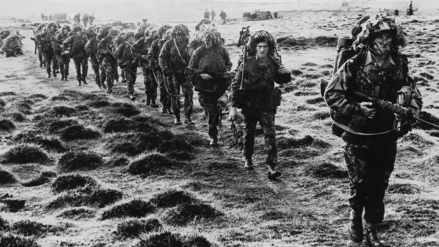 Soldados británicos avanzan por tierra hacia Puerto Argentino/Stanley durante la guerra con Argentina en 1982.