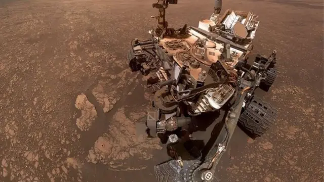 নাসার কিউরিওসিটি রোভার যান মঙ্গল গ্রহে ২০১২ সাল থেকেই অভিযান চালাচ্ছে। একটি পাহাড় চূড়ায় ওঠার সময় এই 'সেলফি' তুলেছে রোবটটি। এখানে পাথর খুড়ে পাওয়া দুইটি নমুনায় কাদার অস্তিত্ব পাওয়া গেছে। কাদায় অনেক সময় পানি মিশে থাকে, যা জীবনের অন্যতম গুরুত্বপূর্ণ উপাদান।