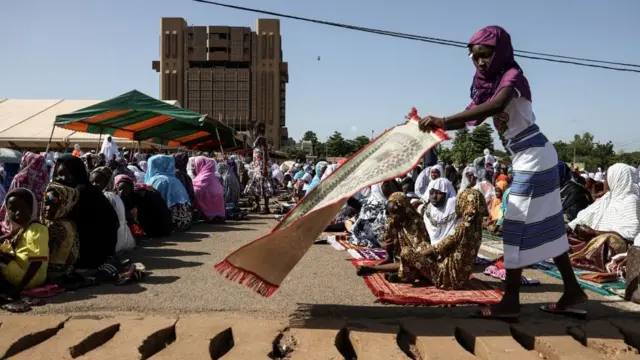Une jeune fille apprêtant son tapis de prière au premier jour de la fête de l'Aïd à Ouagadougou à la place de la nation.