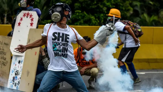 Manifestantes lanzan de vuelta bombas lacrimógenas a las fierzas de seguridad.